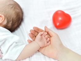 Photo d'une personne tenant la main d'un bébé 